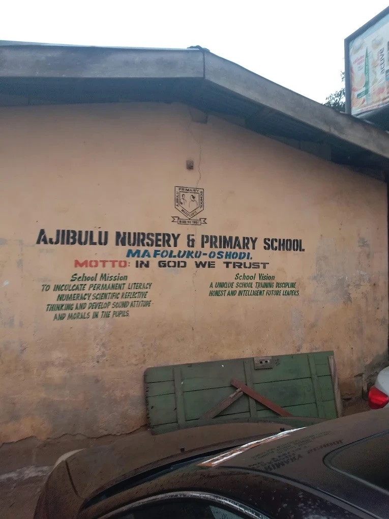 The front wall of Ajibulu Nursery and Primary School in Mafoluku-Oshodi, with the school name, motto, mission and vision painted on it